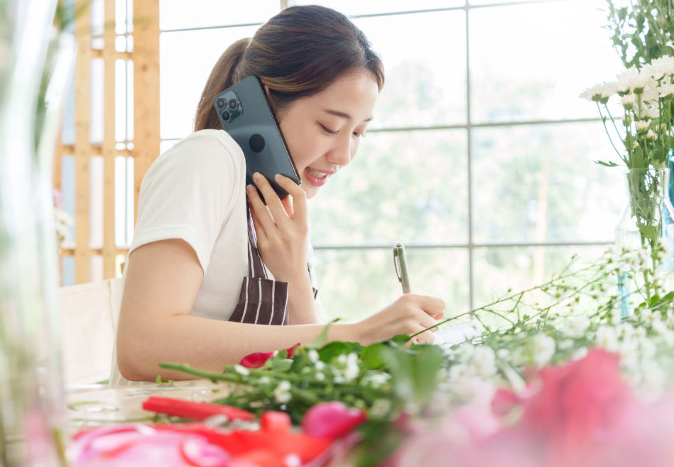 花に囲まれた場所で仕事をする女性